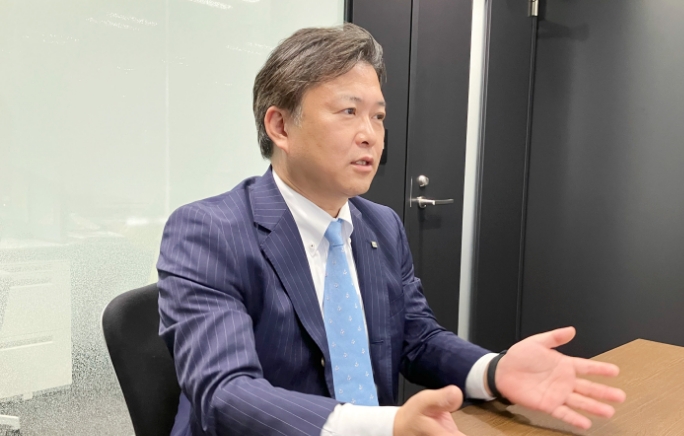 手を広げて話をしている榊田哲也さんの写真