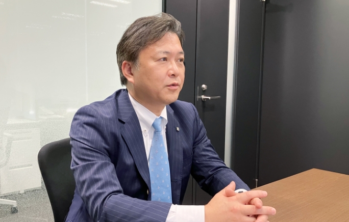 手を組んで話をしている榊田哲也さんの写真
