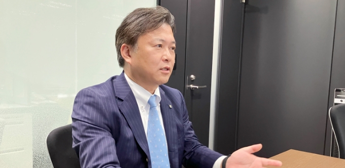手を広げて話をしている榊田哲也さんの写真