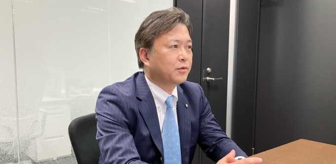 手を組んで話をしている榊田哲也さんの写真